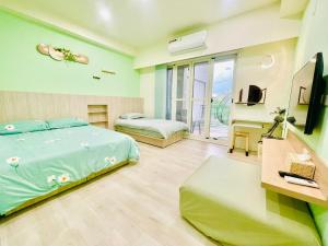 a bedroom with two beds and a television in it at 星月織旅-屏東潮州包棟民宿 in Chaozhou