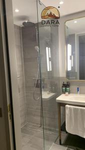 a bathroom with a shower with a glass door at DARA RUM lUXURY CAMP in Wadi Rum
