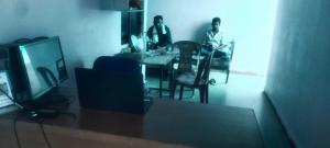 two men sitting at a table in a room at Hotel O Chandrapur Gadchandur formerly Hotel Relax in Chāndur