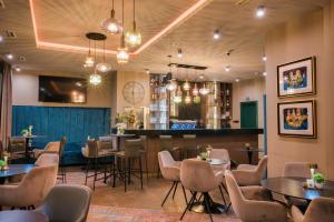 a restaurant with tables and chairs and a bar at Hotel Marina Home in Prijedor