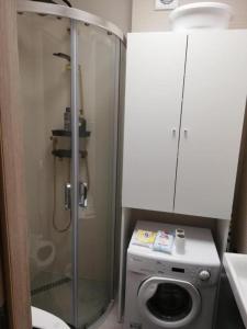 a bathroom with a shower and a washing machine at Attila Beach Boglár in Balatonboglár +9 photos