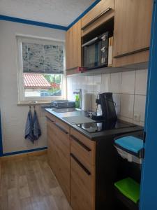 Una pequeña cocina con fregadero y microondas. en beim Anderl, en Oberammergau