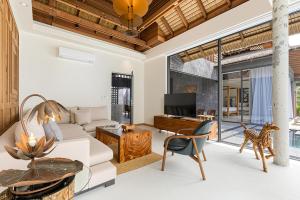 an open living room with a white couch and a table at Private Beach Villa With Sunset Views-On The Sand in Amphoe Koh Samui