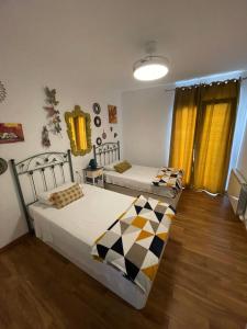 two beds are in a room with wooden floors at Apartahotel Belchite in Belchite
