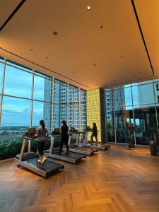 a group of people doing yoga in a room with windows at Apartment Bella Pakuwon City Mall Surabaya 3 pax in Surabaya