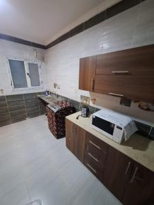 eine Küche mit einer Arbeitsfläche, auf der eine Mikrowelle steht in der Unterkunft كمبوند وصال ريزيدنس أمام مدينتي in Madīnat ash Shurūq