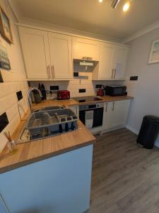 a kitchen with a sink and a counter top at 246, Belle Aire, Hemsby - Two bed recently renovated chalet, sleeps 5, free Wi-Fi, pet friendly, bed linen and towels included with onsite entertainment in Great Yarmouth