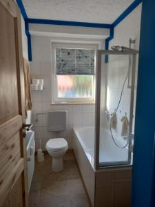 Un baño con bañera, inodoro y ducha. en beim Anderl, en Oberammergau