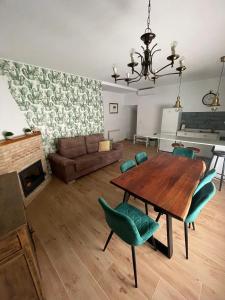 a living room with a wooden table and green chairs at Apartahotel Belchite in Belchite +37 photos
