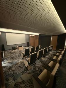 a conference room with chairs and a projection screen at Apartment Bella Pakuwon City Mall Surabaya 3 pax in Surabaya +14 photos