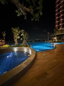 a swimming pool at night with blue lights at Apartment Bella Pakuwon City Mall Surabaya 3 pax in Surabaya