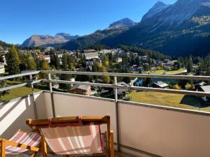 ein Balkon mit zwei Stühlen und Blick auf die Berge in der Unterkunft Fortuna 8 by Arosa Holiday in Arosa