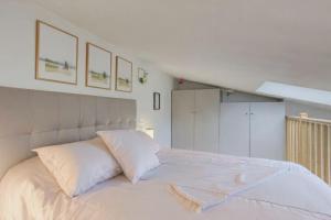 a bedroom with a white bed with two pillows at Le Petit Chalet in Vitry-sur-Seine