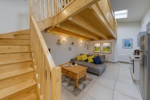 a living room with wooden stairs and a couch at Le Petit Chalet in Vitry-sur-Seine