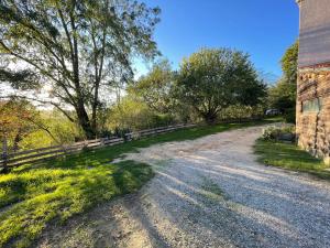 Saint-Barthélemy-de-ValsDomaine des Roches qui Dansent的一条土路,靠近栅栏和树木