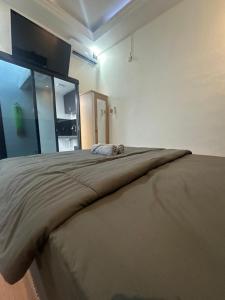 a dog laying on top of a bed in a room at alopa villas in Beran-kidul