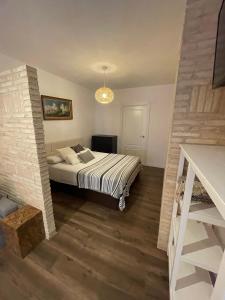 a bedroom with a bed and a brick wall at Apartahotel Belchite in Belchite