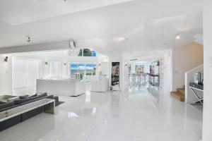 een witte woonkamer met een bank en een tafel bij Villa Moonlight Haven in Miami Beach