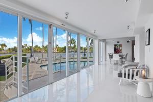 een woonkamer met glazen deuren en een zwembad bij Villa Moonlight Haven in Miami Beach