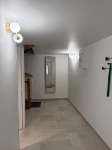 einen Flur mit weißen Wänden und Fliesenboden in der Unterkunft L'aurore des Volcans in Romagnat