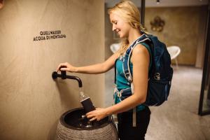 シェーナにあるHilburger Hotelのバックパックを背負った女性がバケツに水を注いでいる +75枚の写真