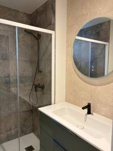 ein Badezimmer mit Waschbecken und Dusche mit Spiegel in der Unterkunft L'aurore des Volcans in Romagnat + 13 Fotos