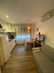 a kitchen and a living room with a couch and a table at Apartahotel Belchite in Belchite