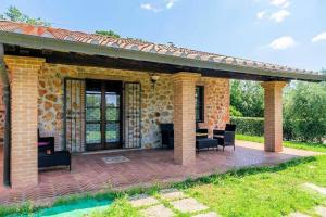 a patio with chairs and a brick building at Alma del Lago - Charming Apartments- il Carpignone in La Pesta
