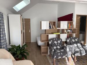 a living room with a couch and a chair at Studio lumineux avec terrasse et jardin proche de Caen 
