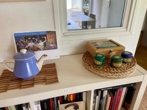 a cabinet with a mirror and a tea pot and books at Les Iris in Bonnieux +15 photos