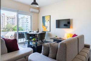 a living room with a couch and a dining room at Ondo 2-Bedroom Apartment in Larnaca
