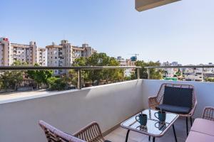 a balcony with chairs and a table with a view at Ondo 2-Bedroom Apartment in Larnaca