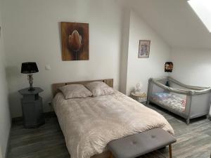 a bedroom with a bed and a crib in it at Le Barbès in Montceau-les-Mines