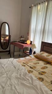a bedroom with a bed and a mirror and a table at Reyan Homestay in Kohīma