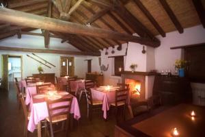 a restaurant with tables and chairs and a fireplace at Agriturismo La Caraffara sull'Etna in Puntalazzo