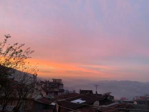 a sunset over a city with roofs and buildings at Reyan Homestay in Kohīma