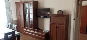a living room with a large wooden cabinet and a tv at Apartament u Basi in Sanok