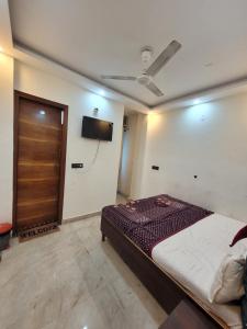 a bedroom with a bed and a flat screen tv at Hotel melbourne sky in New Delhi