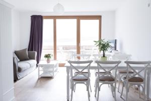 - un salon avec une table et des chaises offrant une vue sur l'océan dans l'établissement Residence Mariagrazia, à Bad Kleinkirchheim