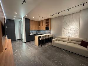 a living room with a couch and a kitchen at Апартаменти на Площі Ринок in Lviv
