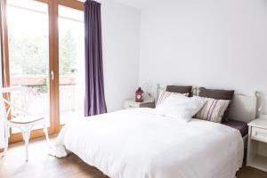 a white bedroom with a large bed and a window at Residence Mariagrazia in Bad Kleinkirchheim