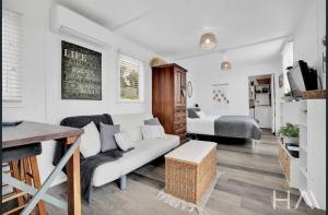 a living room with a couch and a bedroom at Sunrise on the Tamar in Deviot