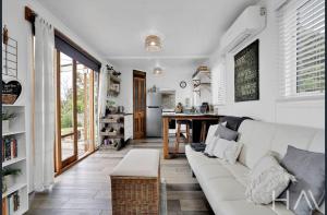 a living room with a white couch and a table at Sunrise on the Tamar in Deviot