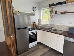 a kitchen with a refrigerator and a stove top oven at Sunrise on the Tamar in Deviot