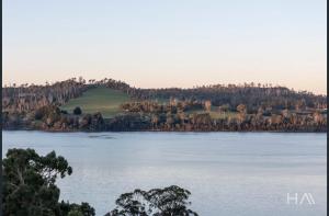 an island in the middle of a large lake at Sunrise on the Tamar in Deviot +2 photos