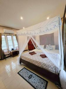 a bedroom with a bed with a canopy at Khaosok Creek and Jungle Resort in Ban Song Phi Nong