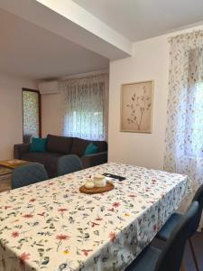a living room with a table with a flowered table cloth at Apartament Draganovi 8B in Kazanlŭk