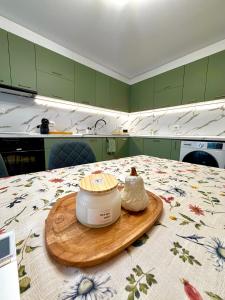 Eine Küche mit grünen Schränken und einem Glas Butter auf einem Tisch in der Unterkunft Apartament Draganovi 8B in Kasanlak