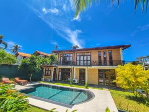 Una vista exterior de una casa con piscina. en Syndeo Garden, en Hikkaduwa