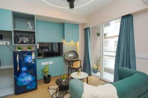 a living room with a blue wall at UHomes Pune airport in Pune